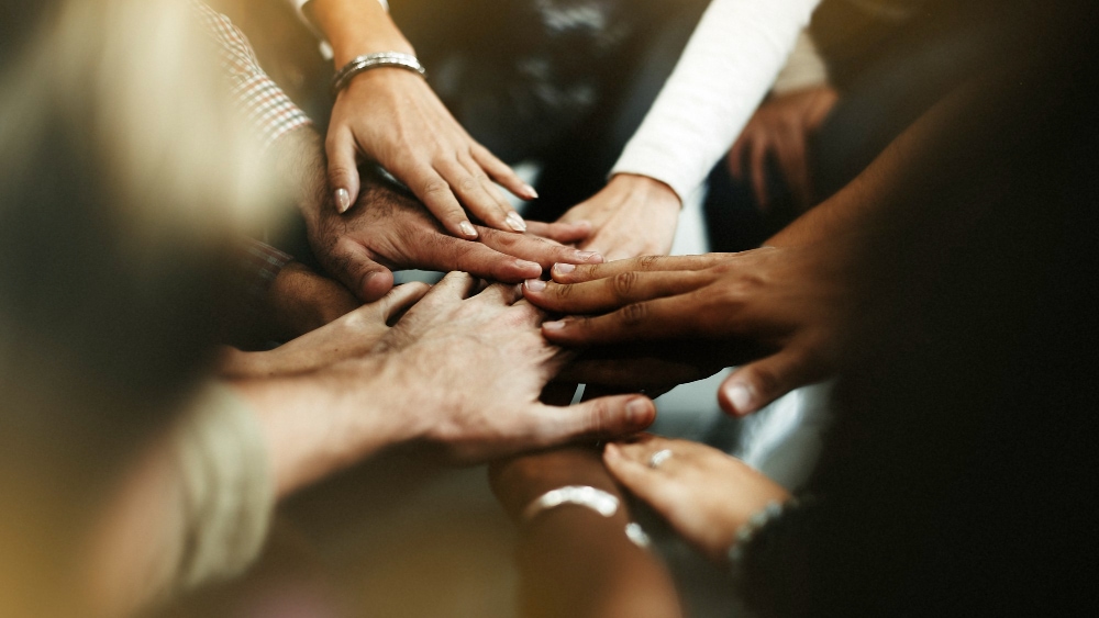 closeup of diverse people joining their hands 1