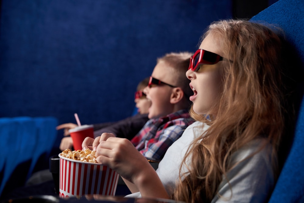 shocked girl with friends watching film in movie house