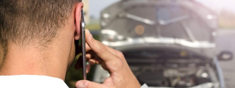 man-standing-by-the-broken-vehicle-calling-tow-service man-standing-by-the-broken-vehicle-calling-tow-service