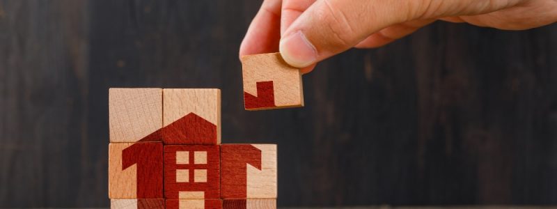 stay-at-home-concept-on-wooden-table-side-view-hand-holding-wooden-cube stay-at-home-concept-on-wooden-table-side-view-hand-holding-wooden-cube